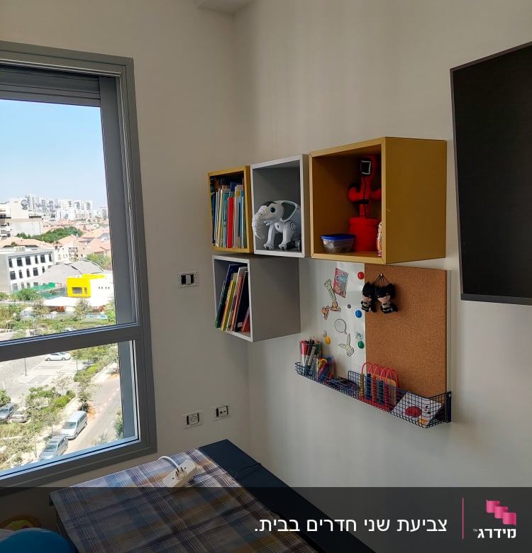 מדף עם ספרים וצעצועים על הקיר